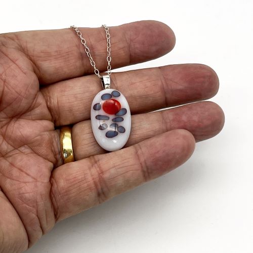 white-red-fused-glass-silver-pendant-necklace oval drop pendant of white fused glass with red and blue pattern mounted on silver and silver chain