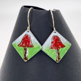 Drop diamond shape earrings with enamel red toadstool on background of grass and sky with silver earwirs